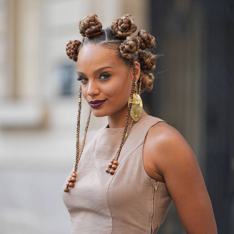 Woman with a bantu knot hairsyle wearing gold earrings