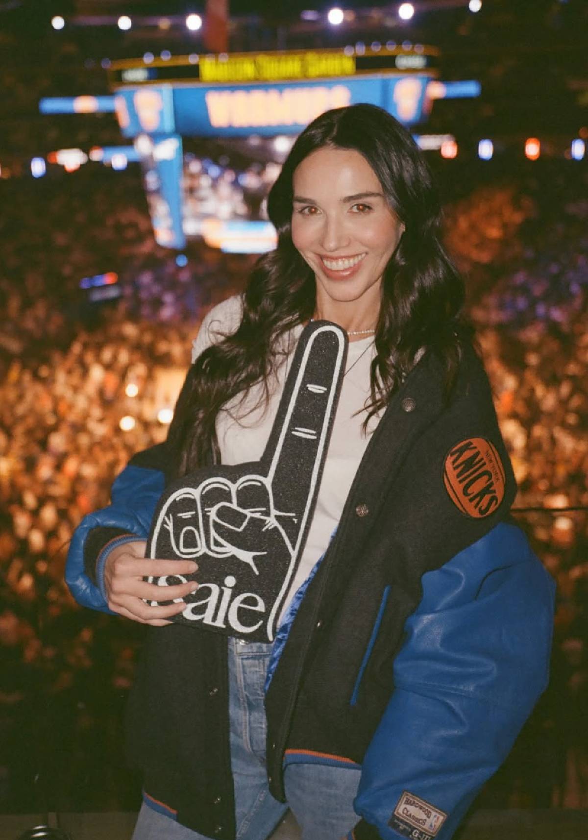 Saie founder Laney Crowell holds a Saie-branded foam finger at a New York Knicks game at Madison Square Garden.