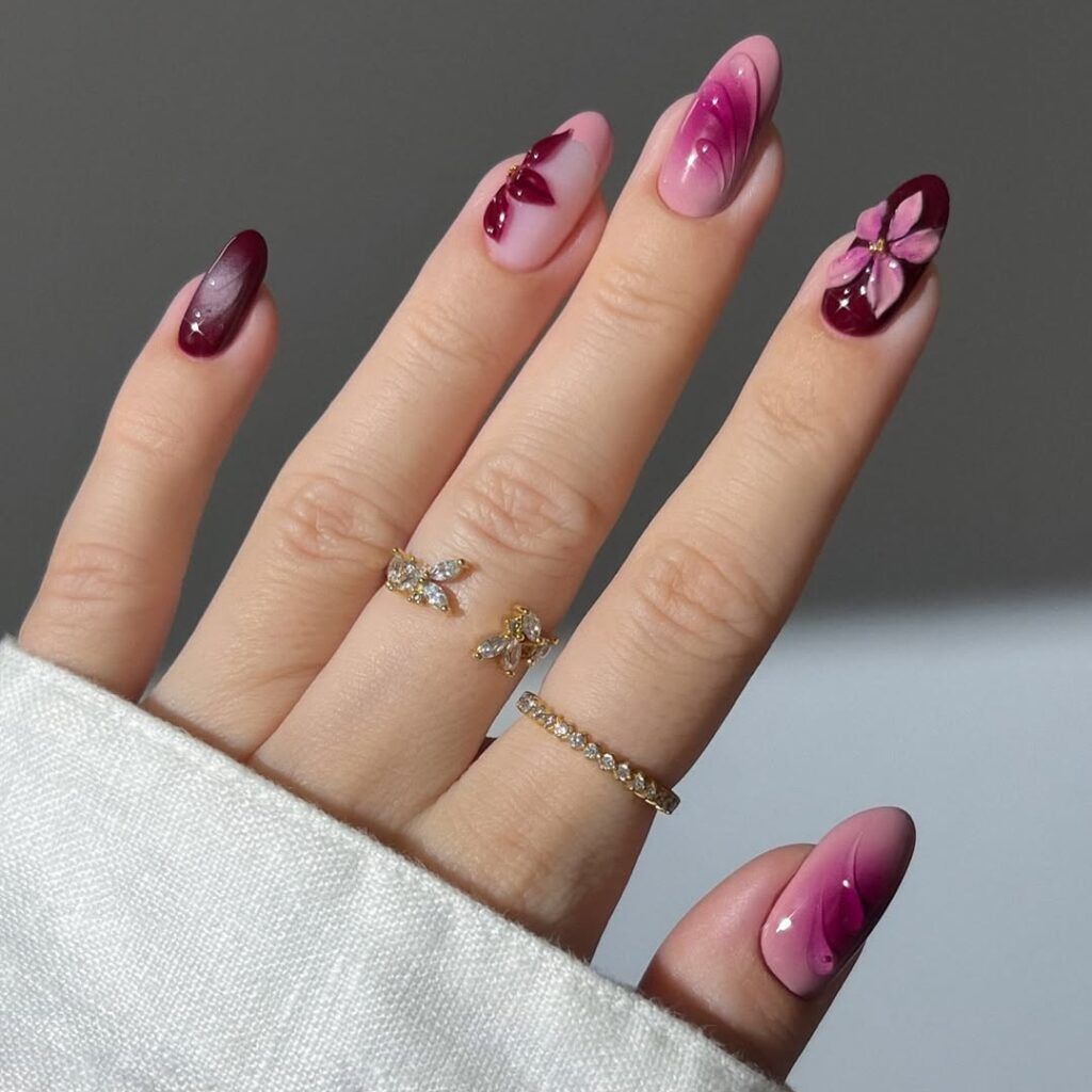 Manicure with burgundy and pink polish and floral nail art