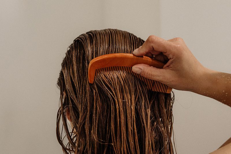 back view of woman combing wet hair