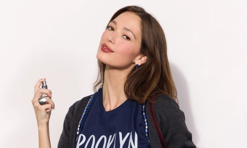 brown haired woman spraying Jones Road BKLYN fragrance