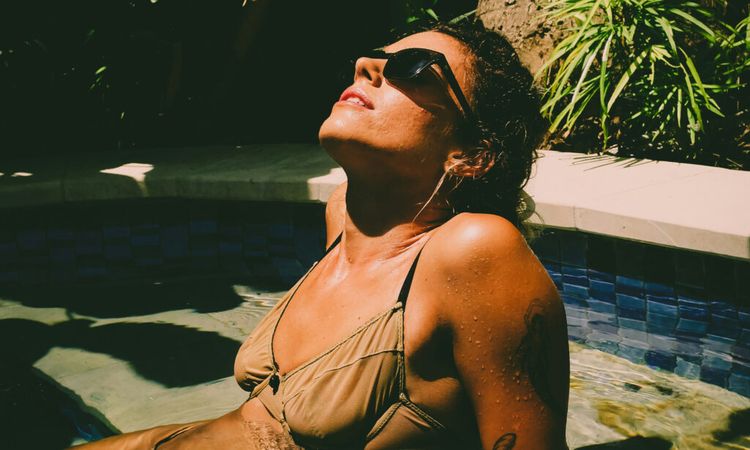 woman wearing sunglasses sunbathing in pool