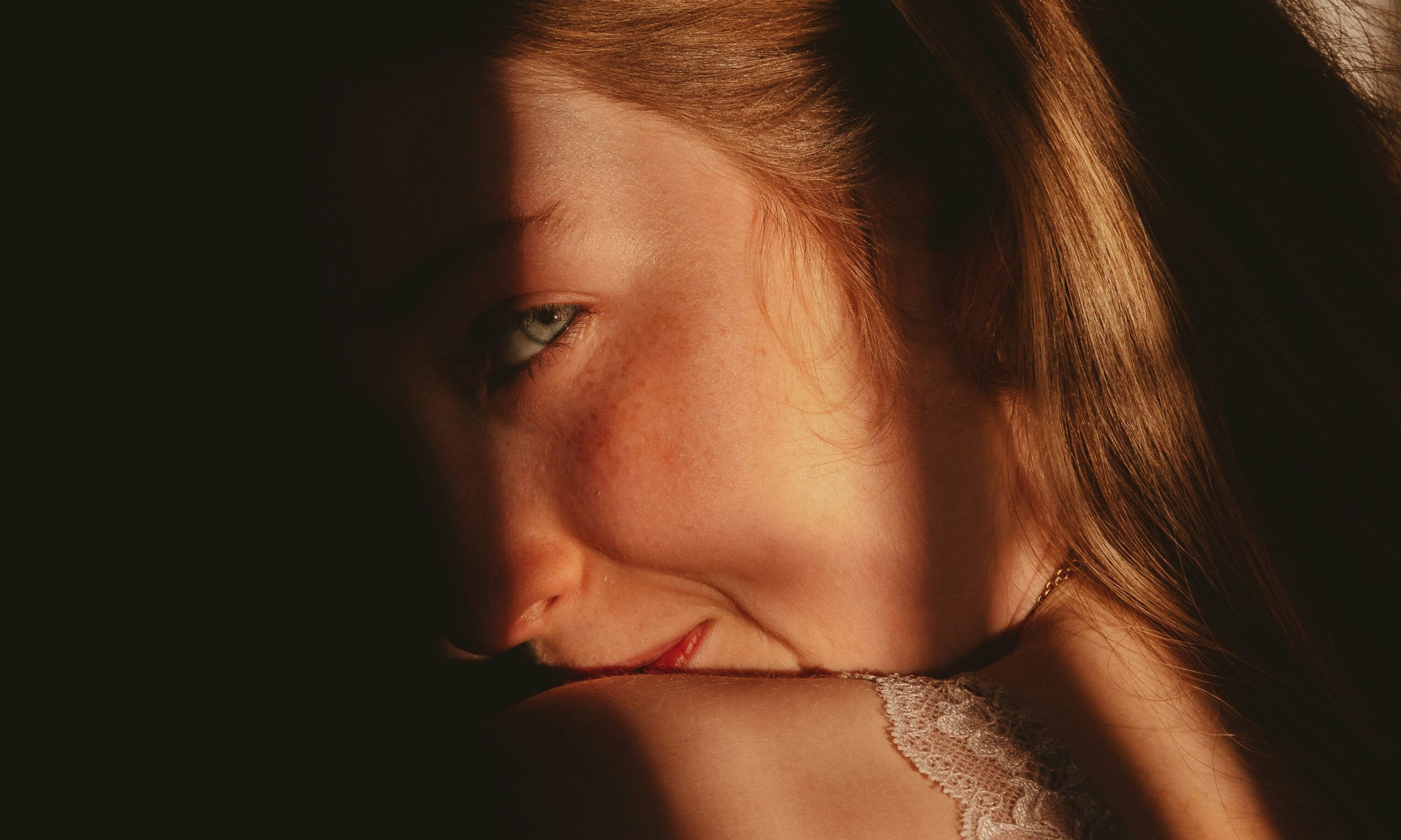 woman in shadows smirking over shoulder