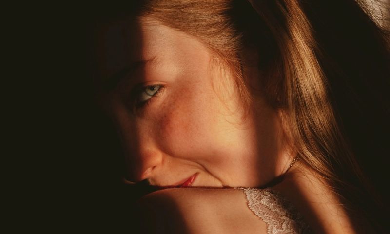 woman in shadows smirking over shoulder