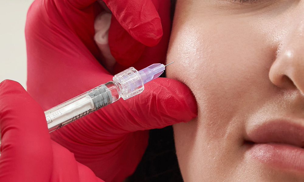 Beautician making injection in female face, closeup.