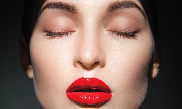 woman with closed eyes in shadows wearing red lipstick