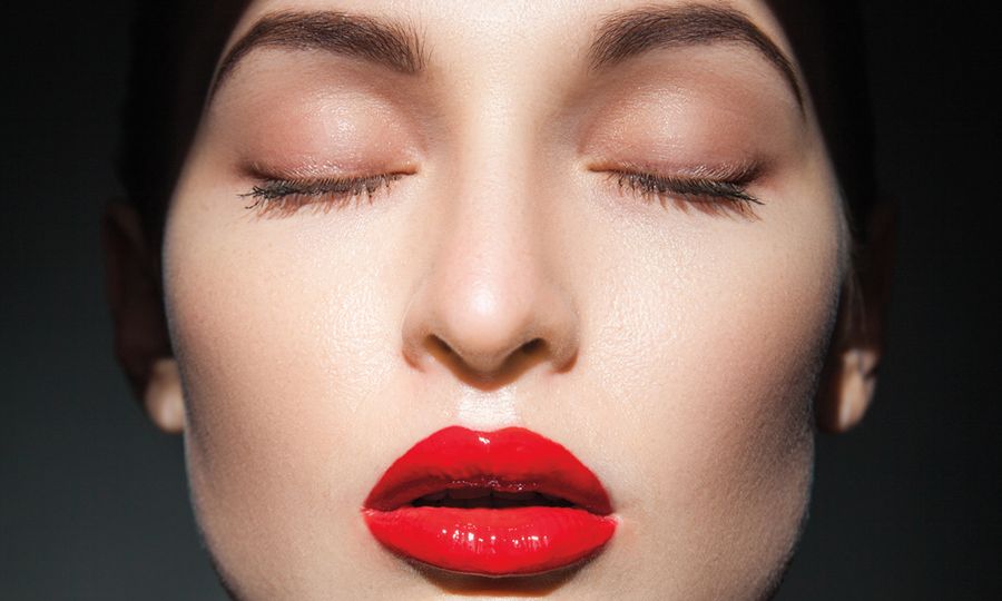 woman with closed eyes in shadows wearing red lipstick