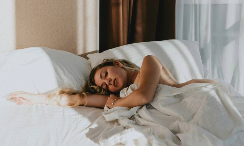 blonde woman laying in bed