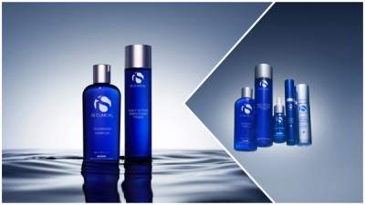 iS Clinical skincare products in blue bottles, with Cleansing Complex and Daily Active Smoothing Toner at left and a wider lineup including Active Serum, GeneXC Firming Eye Gel and Daily Dynamic Hydrator at right.