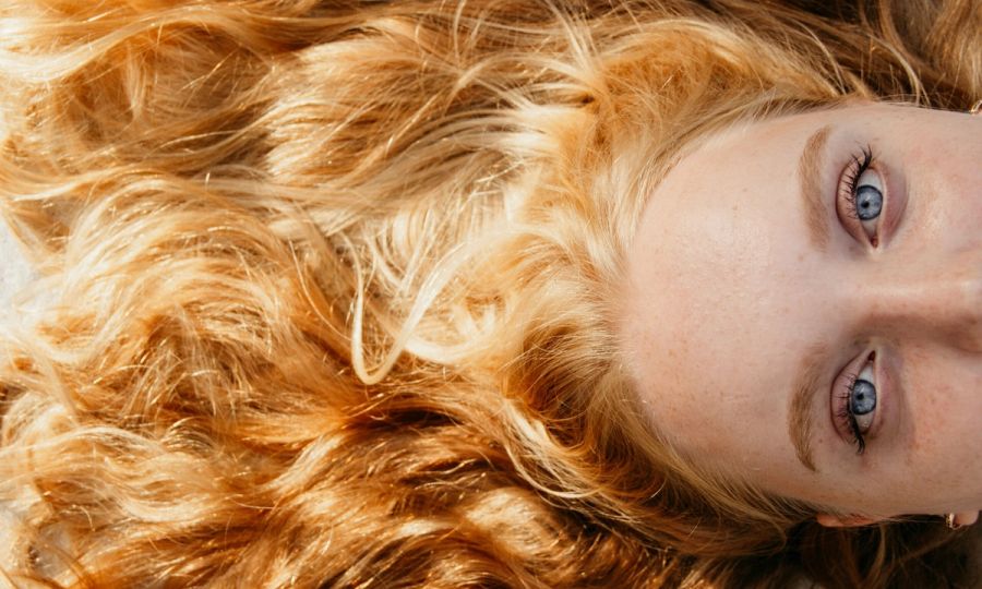 woman with strawberry blonde hair laying flat on ground