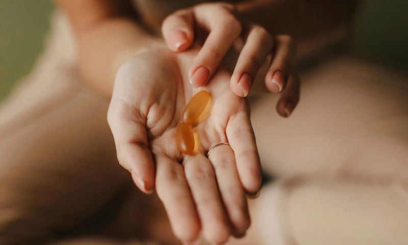 woman's hands with supplement pills in palm