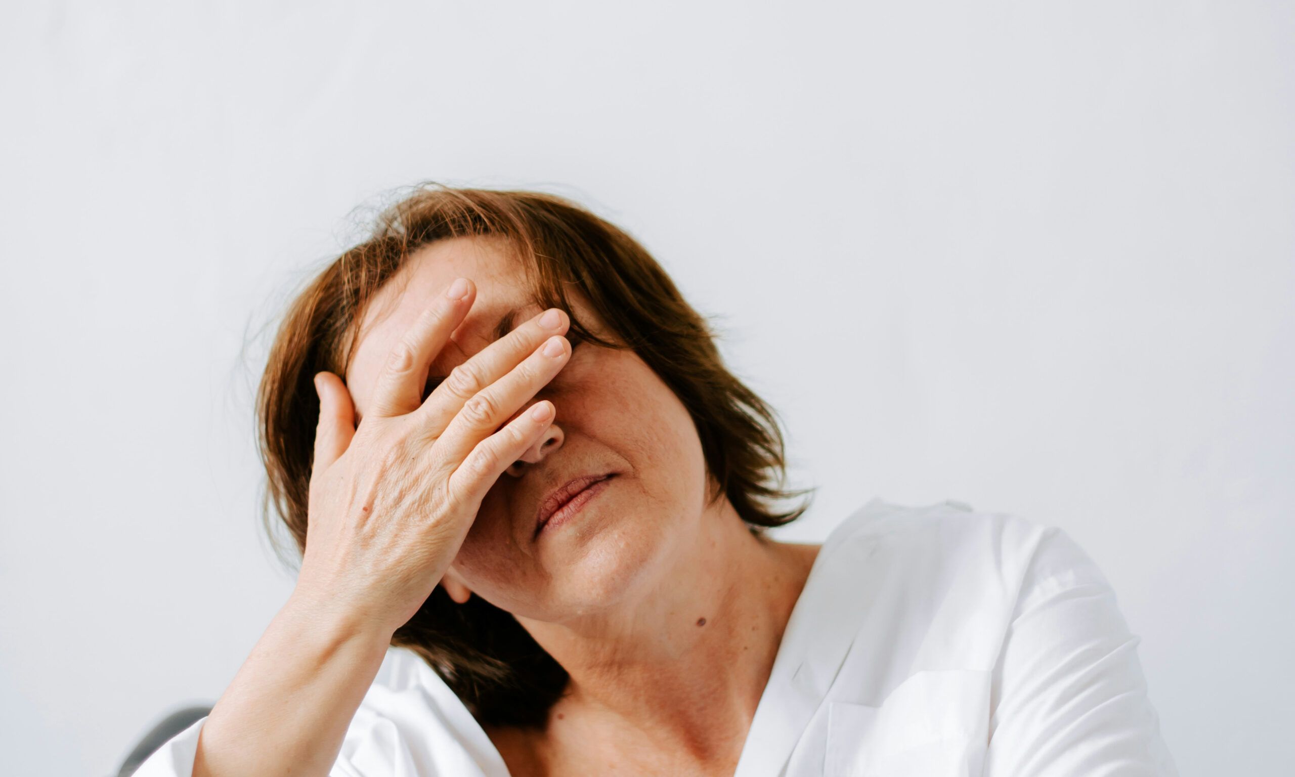 older woman with hands on her face