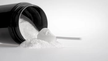 protein powder spilling out of tub with scoop