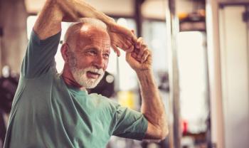 older man stretching in a gym