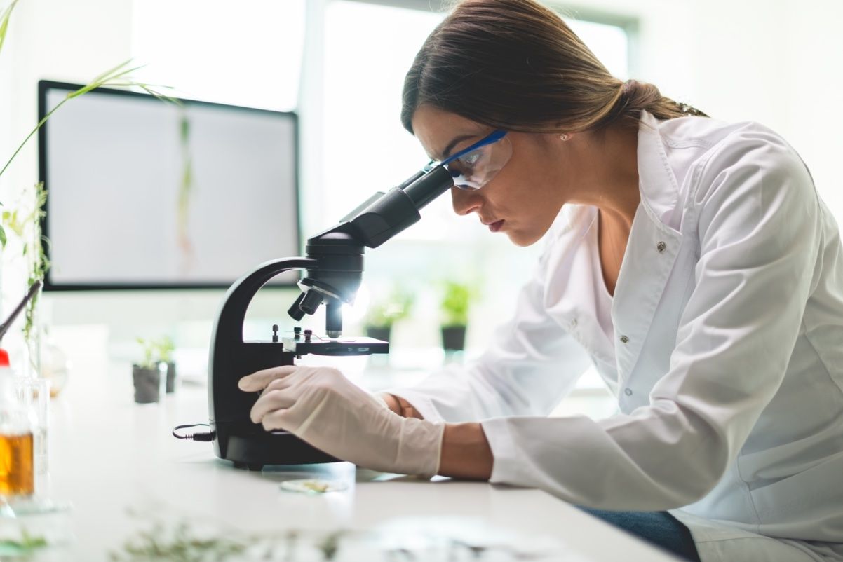 scientist looking through microscope