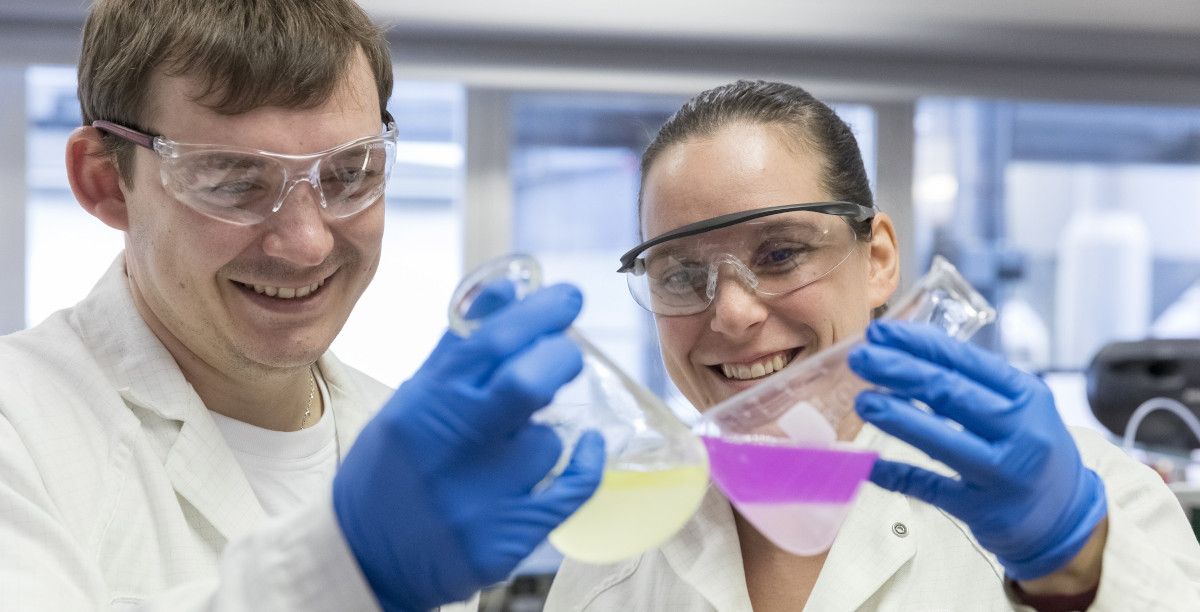 man and woman scientists holding beakers