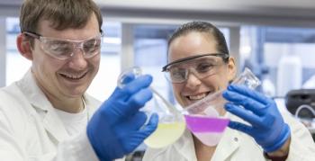man and woman scientists holding beakers
