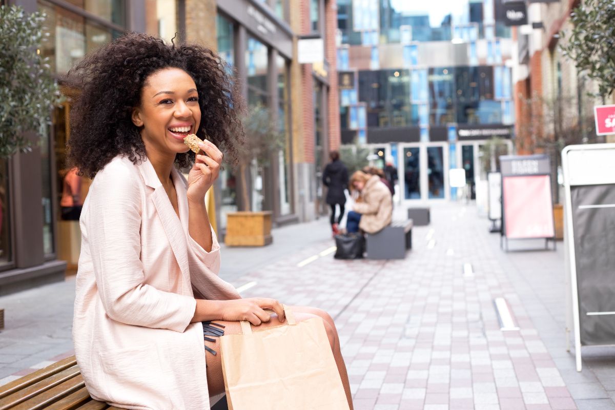woman eating healthy snack on bench outside