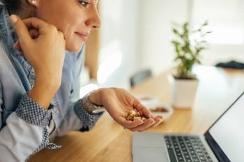 woman at desk snacking on nuts