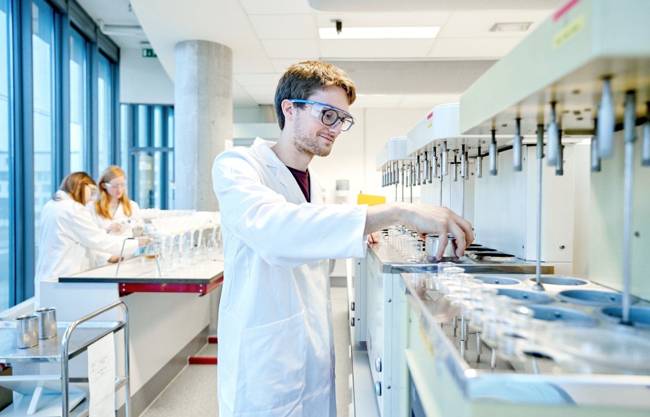 three scientists in lab working with equipment