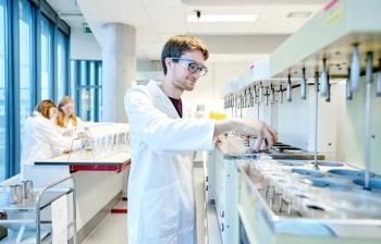 three scientists in lab working with equipment