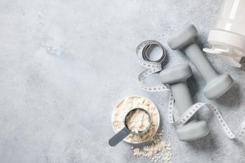 protein powders and dumbbells