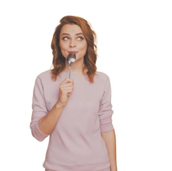 woman with spoon in her mouth savoring flavor