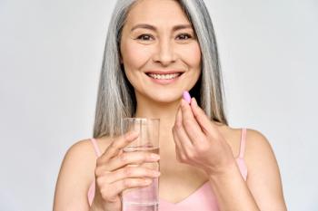 older woman smiling while taking supplement