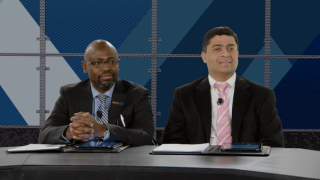 Drs Jared Weiss and Charles Rudin sitting behind a panel desk, smiling at camera.