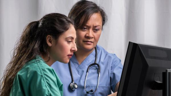 Image of two nurses looking at a computer