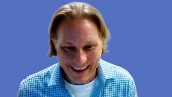 Image of a man with above shoulder-length hair wearing a plaid shirt