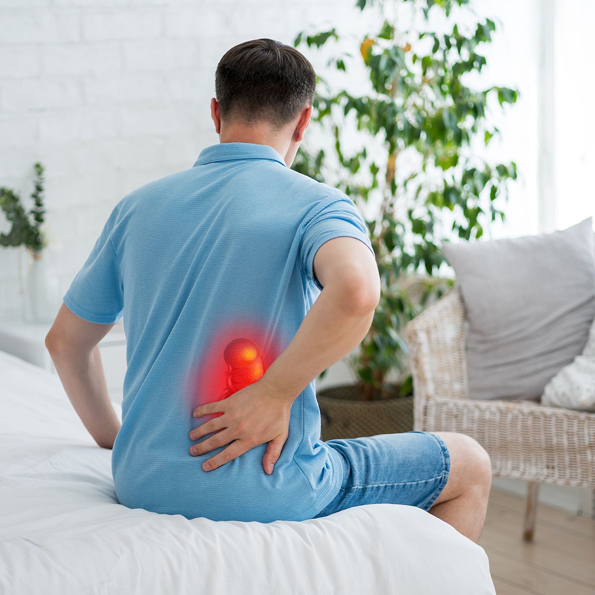 Photo of a main holding his lower back in pain with a graphic of a kidney overlaying