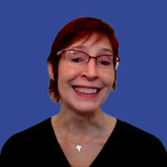 Image of a woman wearing glasses in front of a blue background
