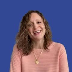 Photo of a woman with curly blond hair in front of a blue background