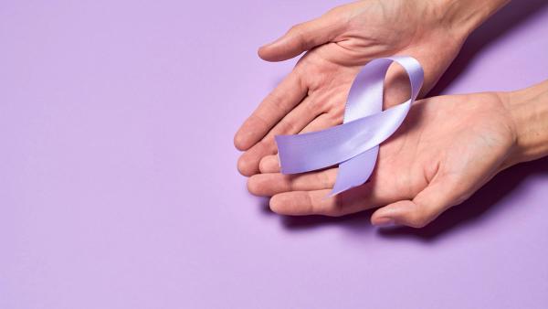 Image of two hands holding a purple ribbon in front of a purple background