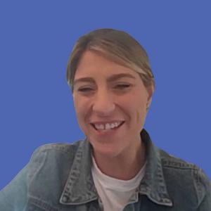 Photo of a woman with blonde hair wearing a denim jacket in front of a blue background