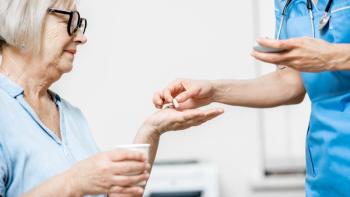 image of a nurse handing a patient a white pill