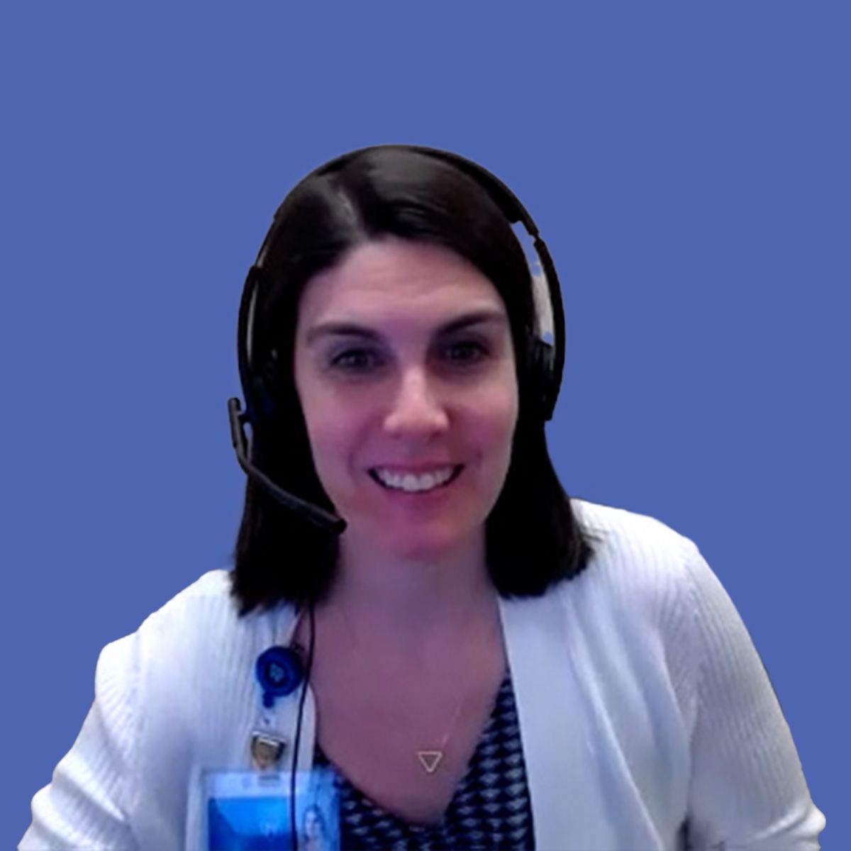 Image of a woman with shoulder-length black hair wearing headphones and a white sweater