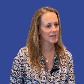 Image of a woman with blond hair in front of a dark blue background