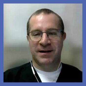 Image of a man in scrubs with short hair and glasses