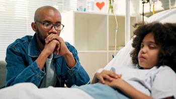 Image of a man looking distressed at a child's hospital bed