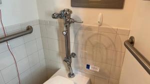 Photo of a hospital bathroom with a Splashblocker toilet seat cover hung on the wall next to it