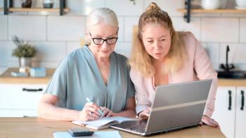 Image of an older woman looking at a computer with a middle-aged woman