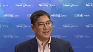 Photo of a man with glasses in a suit in front of an Oncology Nursing News backdrop