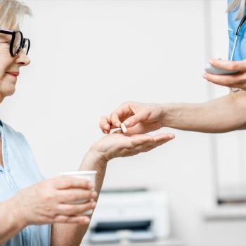 Image of a nurse handing a patient pills
