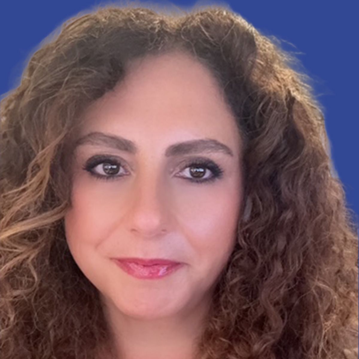 Image of a woman with wavy brown hair in front of a blue background