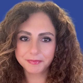 Image of a woman with wavy brown hair in front of a blue background