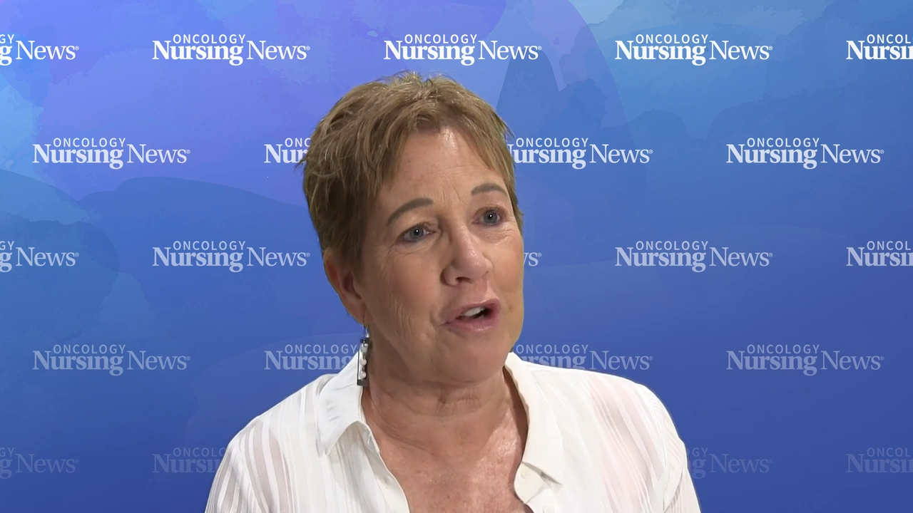 Image of Pattie Jakel, MN, RN, AOCN, in front of a blue watercolor Oncology Nursing News backdrop
