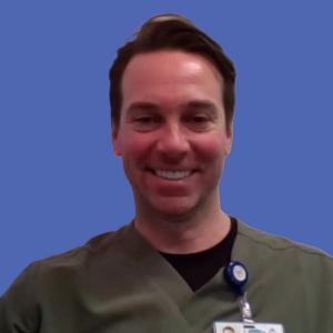 Photo of a man wearing scrubs in front of a blue background