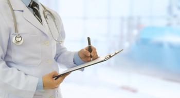 clinician holding and writing on a clipboard